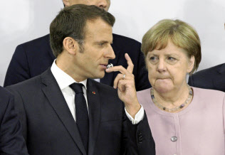 混乱のなか、マクロン仏大統領(左)とメルケル独首相の「密談」で人事の最終案が決まった(6月29日、G20大阪サミット)=AP 混乱のなか、マクロン仏大統領(左)とメルケル独首相の「密談」で人事の最終案が決まった(6月29日、G20大阪サミット)=AP