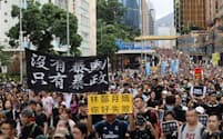 香港のデモは収束の兆しが見えない（7日、繁華街を行進する参加者）