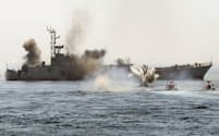 ホルムズ海峡で船舶を襲撃する訓練をするイラン革命防衛隊の小型ボート（手前右）=ロイター