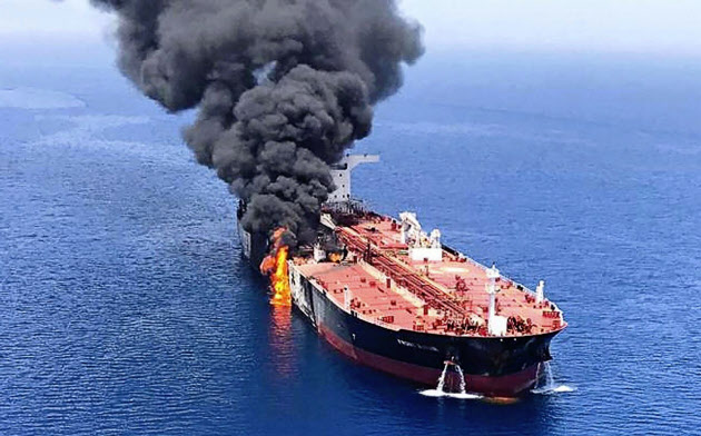 ホルムズ海峡付近で攻撃を受けて火災を起こし、煙を上げるタンカー=AP ホルムズ海峡付近で攻撃を受けて火災を起こし、煙を上げるタンカー=AP