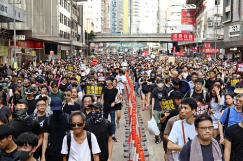 幹線道路を行進するデモ参加者(21日、香港)