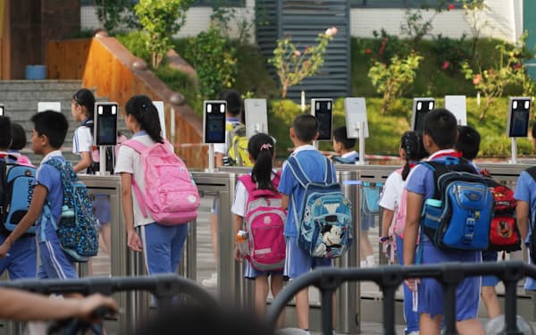 小学校の校門に設置された顔認証ゲートを通って登校する児童（中国・深圳）