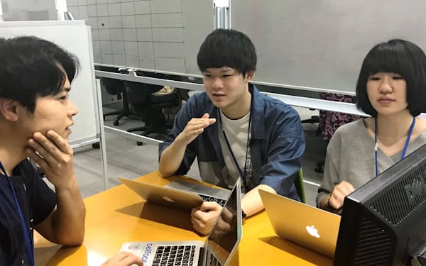 インターン中、社員（写真左）と相談する学生たち（東京都新宿区）