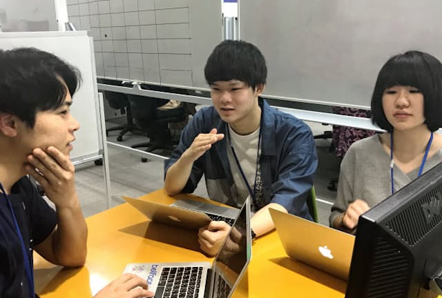 インターン中、社員（写真左）と相談する学生たち（東京都新宿区）