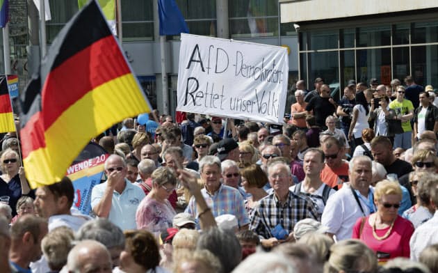 極右政党「ドイツのための選択肢(AfD)の名が入った幕を掲げる人々=AP 極右政党「ドイツのための選択肢(AfD)の名が入った幕を掲げる人々=AP