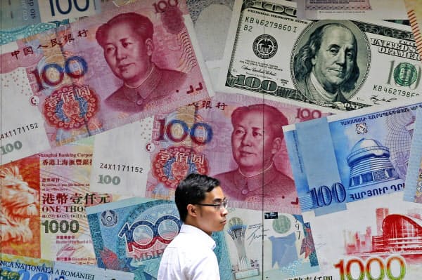 中国・人民元など紙幣イメージが掛かる香港の外貨両替店=AP