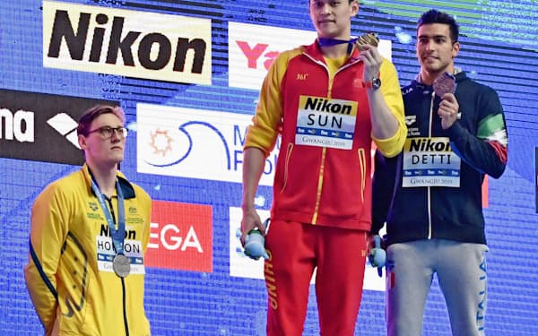 男子400メートル自由形の表彰式。金メダルを手にする孫楊（中央）と表彰台に上がらず抗議の意志を示すオーストラリアのホートン（左）=共同