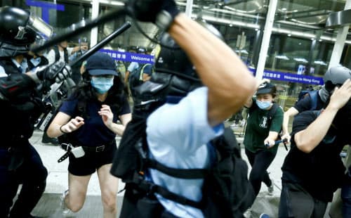 香港国際空港で衝突する警察とデモ隊(13日)=ロイター