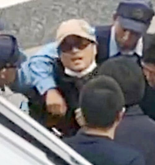 大阪市東住吉区の路上で、茨城県警の捜査員らに確保される宮崎文夫容疑者(18日午前)=近隣住民提供・共同