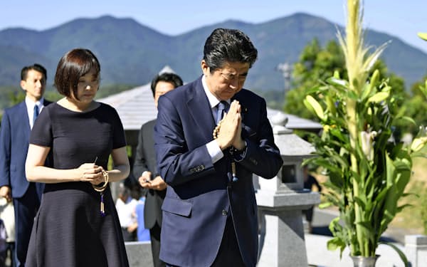 父の晋太郎元外相の墓前で手を合わせる首相。左は昭恵夫人（13日、山口県長門市）