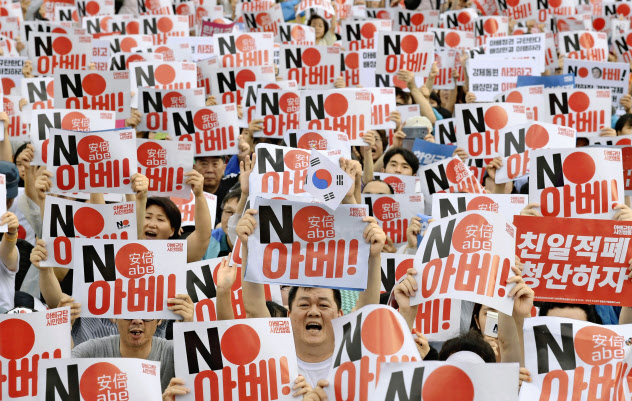 15日、ソウル中心部の光化門広場で「ノー安倍」と書かれたプラカードを掲げる集会参加者(共同) 15日、ソウル中心部の光化門広場で「ノー安倍」と書かれたプラカードを掲げる集会参加者(共同)
