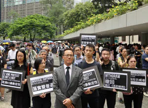 23日、会計事務所の従業員らが香港島中心部でデモ行進した