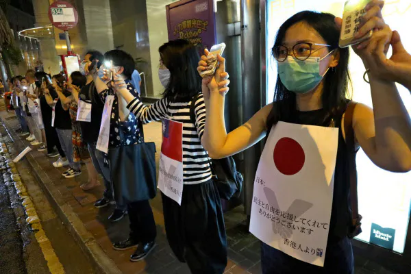「人間の鎖」の参加者はデモへの支援に感謝するプラカードを掲げた(23日夜、香港)