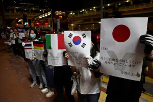 プラカードには日本語で「ありがとうございます」の言葉も(23日夜、香港)