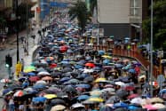 雨の中、多くの人がデモ行進した(25日、香港・葵芳)=ロイター 雨の中、多くの人がデモ行進した(25日、香港・葵芳)=ロイター