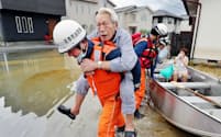 九州北部を襲った大雨で浸水した自宅から救助される男性ら（8月29日、佐賀県大町町）