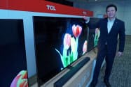次世代ディスプレー技術「量子ドット」を採用した4K対応テレビ「X10シリーズ」と記念撮影に応じるTCLジャパンエレクトロニクスの李炬代表取締役(29日午後、東京都中央区)
