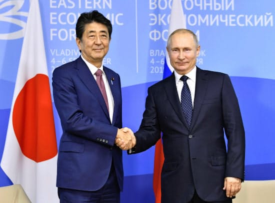 会談前、握手するロシアのプーチン大統領(右)と安倍首相(5日、ロシア・ウラジオストク)=共同