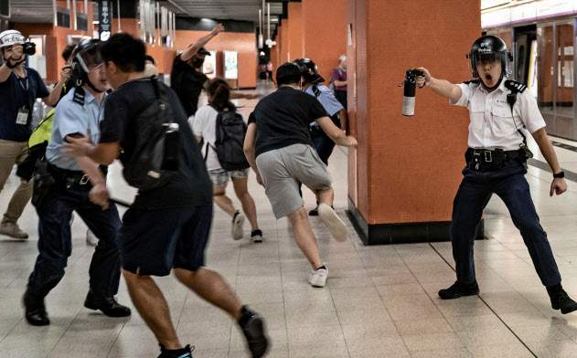 5日、香港の鉄道駅で、催涙スプレーでデモ隊を排除しようとする警官(ゲッティ=共同) 5日、香港の鉄道駅で、催涙スプレーでデモ隊を排除しようとする警官(ゲッティ=共同)