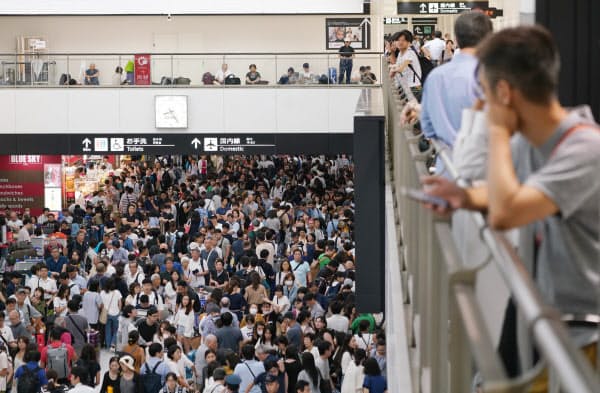 混雑する成田空港の到着ロビー(9日夜)