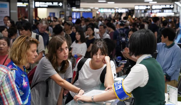 到着ロビーでは、足止めされた利用客らで混乱が続いた(9日夜)