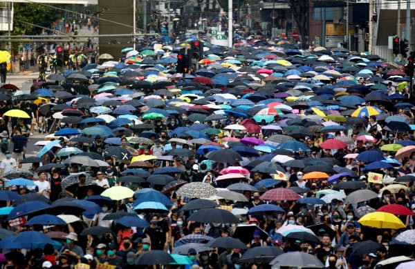 無許可にかかわらず、多くの人がデモ行進に参加した(15日、香港)=ロイター