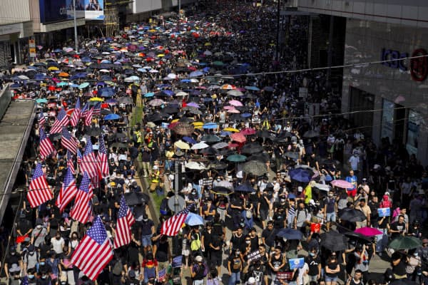 米国旗を持った集団もデモ行進に参加した(15日、香港)=AP