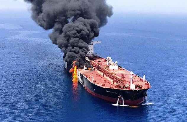 6月、ホルムズ海峡付近で攻撃を受けて火災を起こし、オマーン湾で煙を上げるタンカー=AP 6月、ホルムズ海峡付近で攻撃を受けて火災を起こし、オマーン湾で煙を上げるタンカー=AP