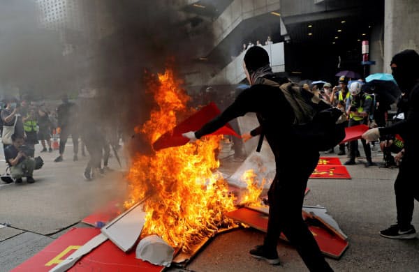 29日、デモ隊は中国建国70周年を祝うボードを燃やした=ロイター