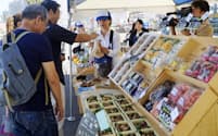 豊洲市場の開場から1周年となるのを前に開かれた記念イベントで、野菜などを買い求める人たち（5日午前、東京都江東区）=共同