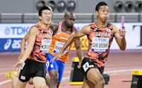 陸上の世界選手権男子400メートルリレー決勝で、第3走者の桐生（左）からバトンを受け走りだすアンカーのサニブラウン（右）=共同