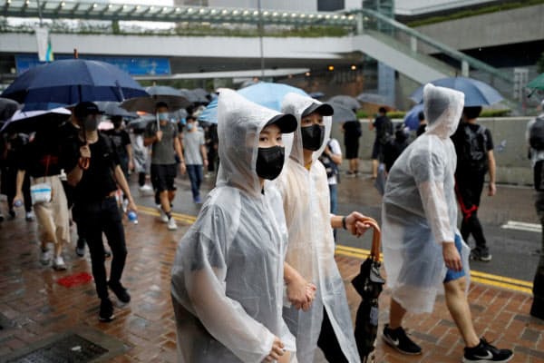 6日、香港では多くの人がマスク姿でデモに参加した=ロイター