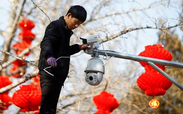 米国は中国の監視カメラ最大手ハイクビジョンを調達禁止の対象としている（北京で同社製品を設置する作業員）=ロイター