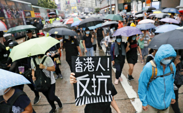 「香港人、反抗せよ」と叫びながらマスク姿で覆面禁止に抗議する人たち(6日、香港)=共同 「香港人、反抗せよ」と叫びながらマスク姿で覆面禁止に抗議する人たち(6日、香港)=共同
