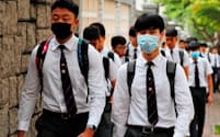 8日、香港ではマスク姿で登校する生徒が目立った=ロイター