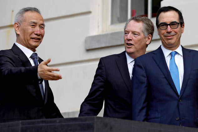 10日、ワシントンのUSTR入り口で劉氏(左)を出迎えたライトハイザー氏(中)とムニューシン氏=ロイター 10日、ワシントンのUSTR入り口で劉氏(左)を出迎えたライトハイザー氏(中)とムニューシン氏=ロイター