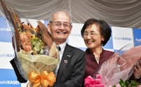 記者会見で花束を手に笑顔を見せる旭化成の吉野彰名誉フェロー(左)と妻の久美子さん（10日、東京都千代田区）