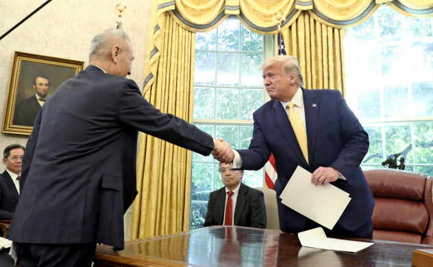 ホワイトハウスで握手するトランプ米大統領と劉鶴・中国副首相(11日、ワシントン)=AP ホワイトハウスで握手するトランプ米大統領と劉鶴・中国副首相(11日、ワシントン)=AP