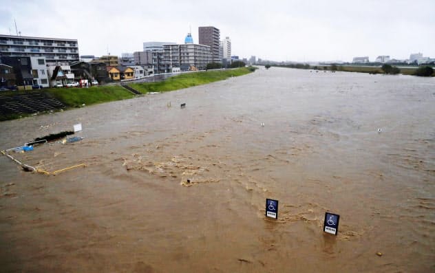 台風19号の影響で増水した多摩川(12日午後4時27分、東京都大田区)=共同 台風19号の影響で増水した多摩川(12日午後4時27分、東京都大田区)=共同