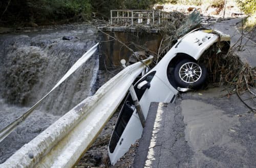台風19号の大雨による影響で陥没した道路の路肩に落ちた乗用車(13日午前、宮城県角田市)=共同