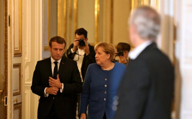 13日、メルケル独首相(右)とマクロン仏大統領(左)はパリで会談した=ロイター 13日、メルケル独首相(右)とマクロン仏大統領(左)はパリで会談した=ロイター