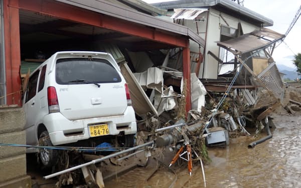 濁流に流されたとみられる車が民家に突っ込んでいた（14日、長野市）