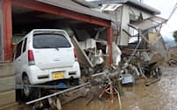 濁流に流されたとみられる車が民家に突っ込んでいた（14日、長野市）