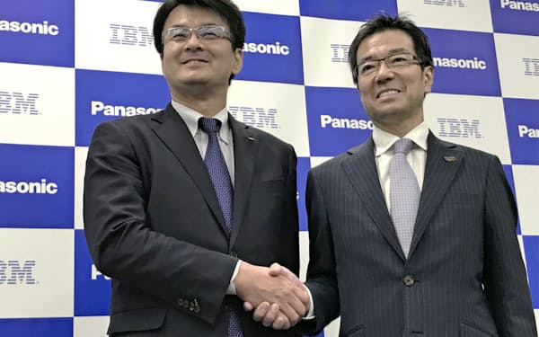協業の発表会見で握手する日本IBMの山口明夫社長（左）とパナソニックの樋口泰行専務（15日、大阪市）