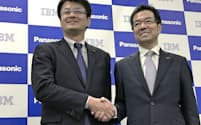 協業の発表会見で握手する日本IBMの山口明夫社長（左）とパナソニックの樋口泰行専務（15日、大阪市）