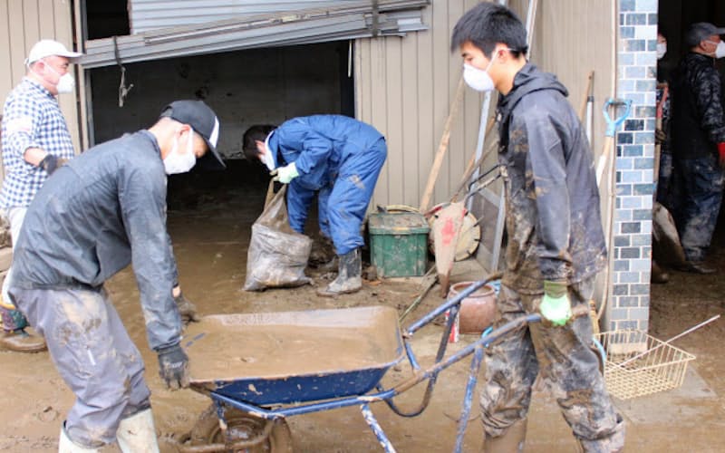 家屋に流入した泥をボランティアらが一輪車で何回も運び出す(19日、長野市) 家屋に流入した泥をボランティアらが一輪車で何回も運び出す(19日、長野市)