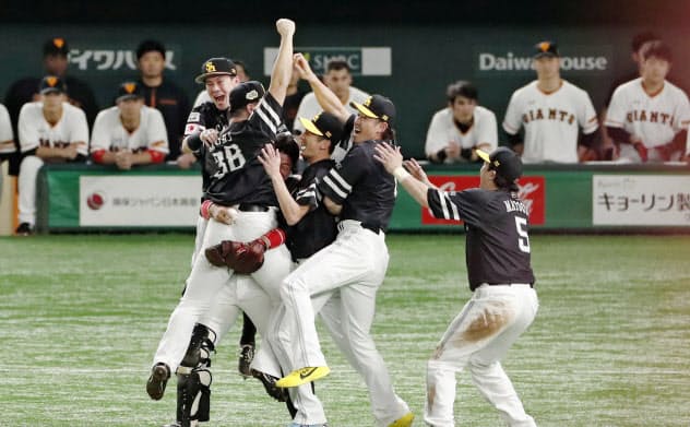 日本シリーズ3連覇を果たし、沈黙する巨人ベンチの前で喜ぶソフトバンクナイン=共同 日本シリーズ3連覇を果たし、沈黙する巨人ベンチの前で喜ぶソフトバンクナイン=共同