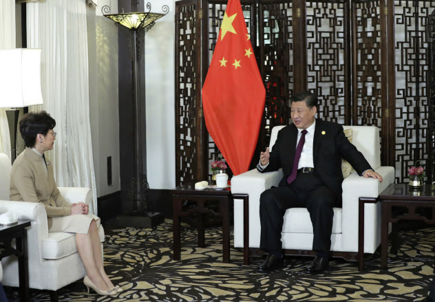 習近平国家主席(右)と会談する香港の林鄭月娥行政長官(4日、上海)=新華社・AP 習近平国家主席(右)と会談する香港の林鄭月娥行政長官(4日、上海)=新華社・AP