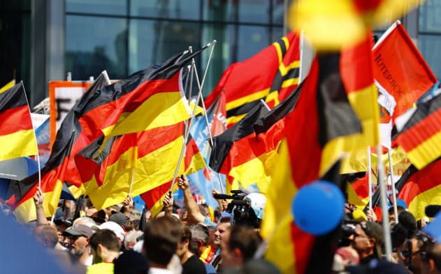 極右政党「ドイツのための選択肢（ＡｆＤ）」の集会では多くの参加者がドイツ国旗を持つ（2018年＝ロイター）