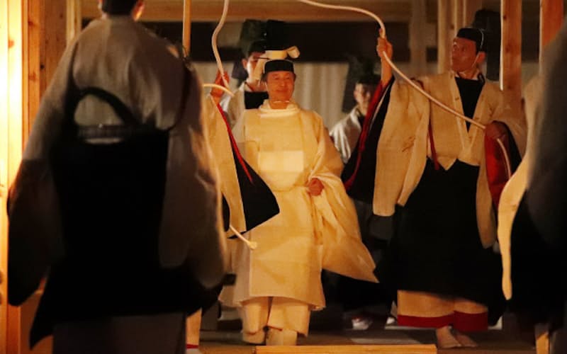 薄明かりの中、「悠紀殿供饌の儀」のため、祭服を着て悠紀殿に向かう天皇陛下(14日、皇居・東御苑)=代表撮影 薄明かりの中、「悠紀殿供饌の儀」のため、祭服を着て悠紀殿に向かう天皇陛下(14日、皇居・東御苑)=代表撮影